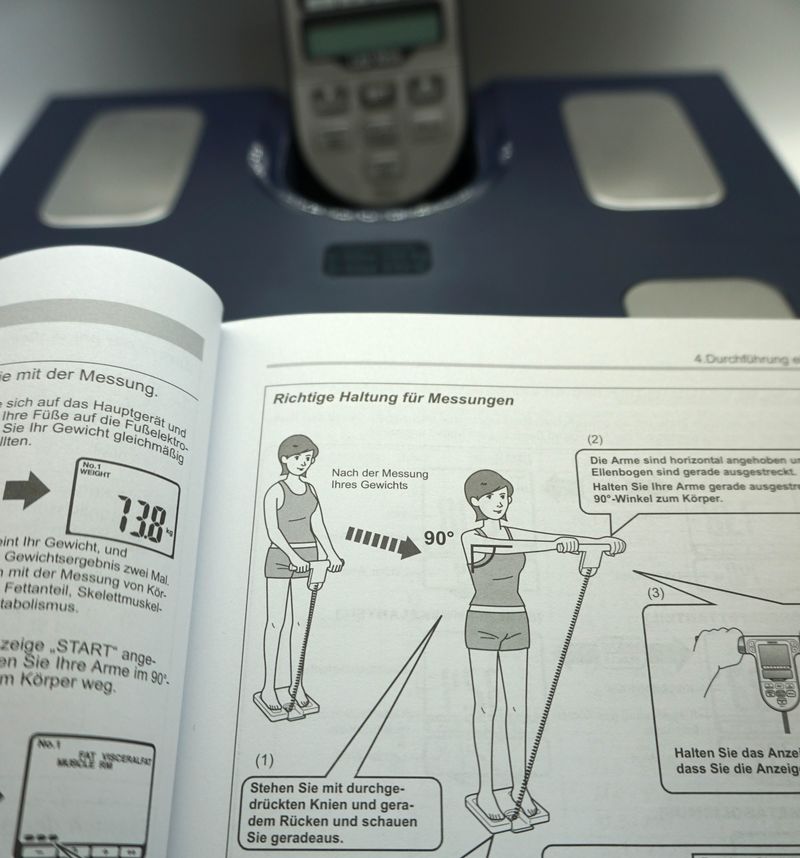 Das Handstück der Omron BF511 Ganzkörperanalysewaage wird - wie in der Anleitung erläutert - mit nach vorne ausgestreckten Händen gehalten, um u.a. "Kurzschlüsse" des elektrischen Signals zwischen Armen und Oberkörper zu verhindern
